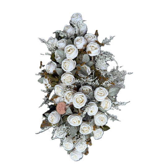 Decorative wreath with white flowers and greenery on a white background