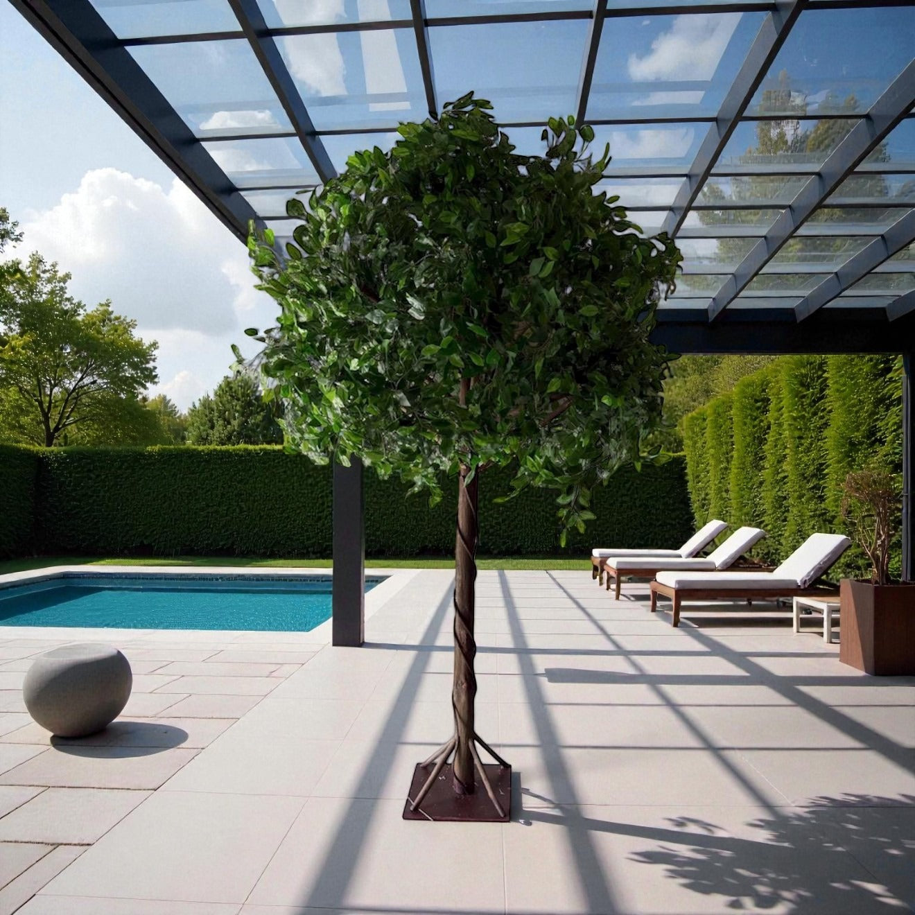 Decorative tree in a garden setting with a pool and lounge chairs.