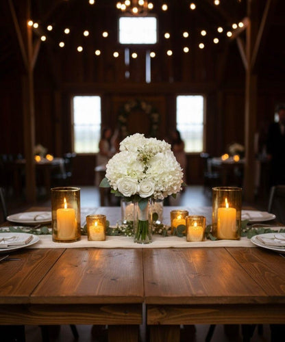 Decorated table with white flowers and candles in a rustic setting