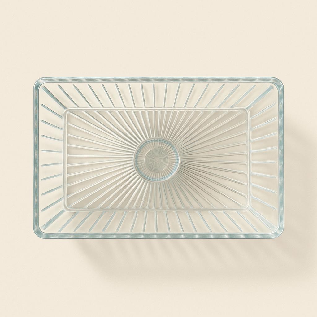 Clear glass rectangular bowl with starburst pattern on a beige background