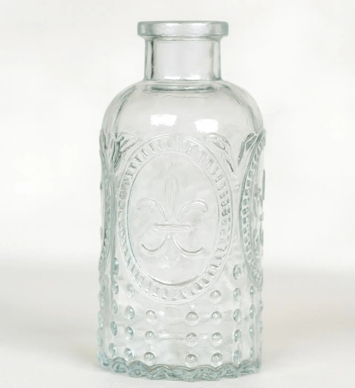 Clear glass bottle with embossed design on a white background