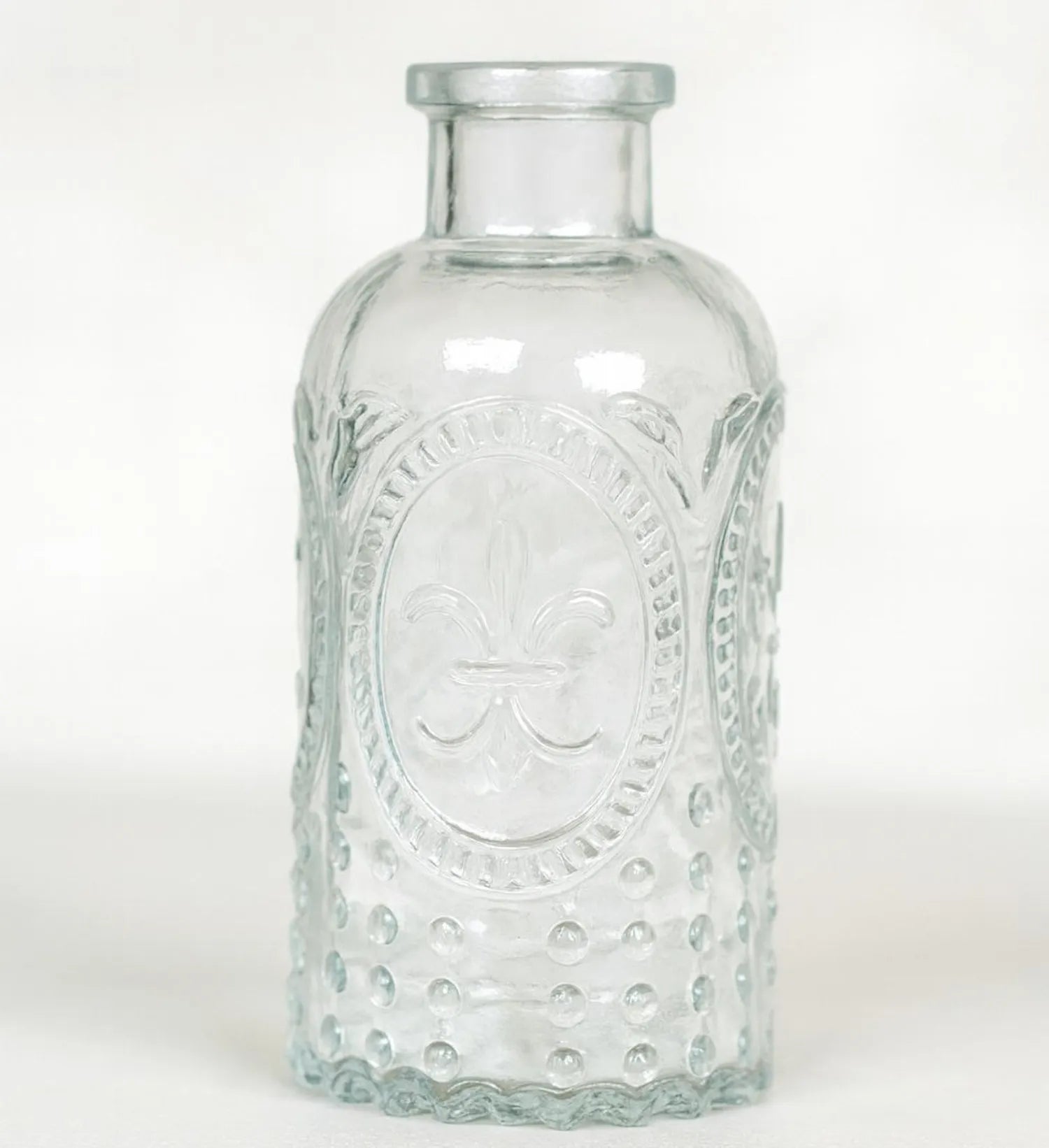 Clear glass bottle with embossed design on a white background