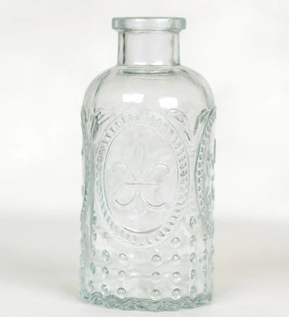 Clear glass bottle with embossed design on a white background