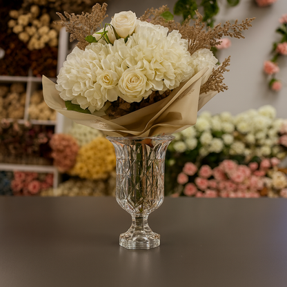 Bouquet of white flowers in a crystal vase with a blurred floral background