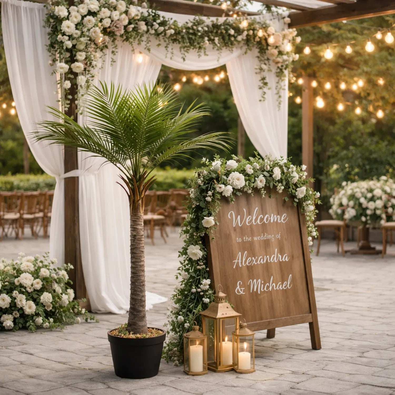 Decorative wedding setup with floral arch, potted palm tree, and welcome sign.