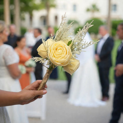 Bouquet of yellow roses held in front of a blurred wedding scene