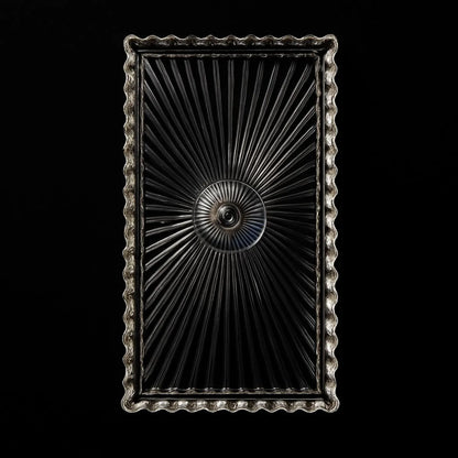 Decorative metal object with intricate design on a black background