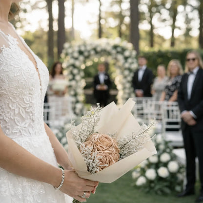 Bride holding a bouquet at an outdoor wedding ceremony with guests in the background.