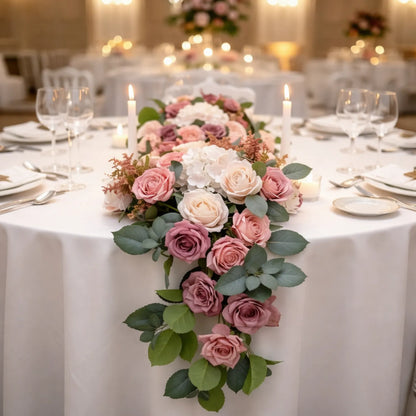 Decorative floral arrangement on a table with a formal setting in the background