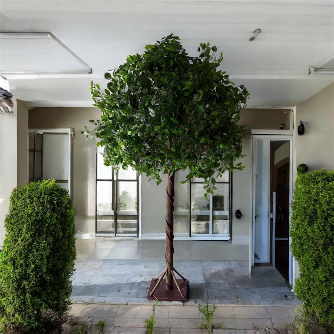 Artificial tree in a decorative pot on a patio with a modern building in the background