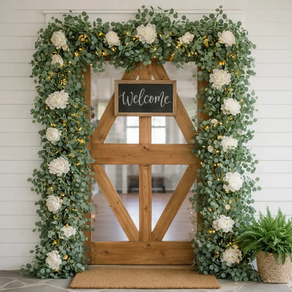 Decorative entrance with wooden door, floral arch, and 'Welcome' sign.