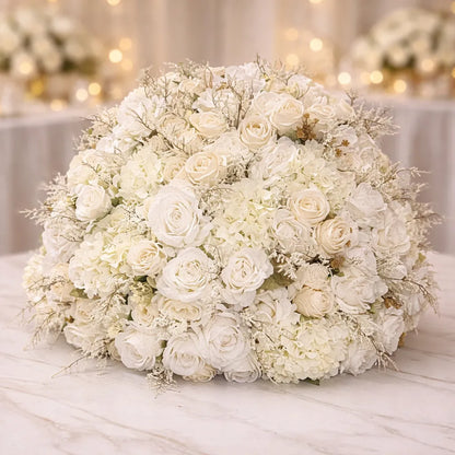 Large bouquet of white flowers on a marble surface with blurred floral background