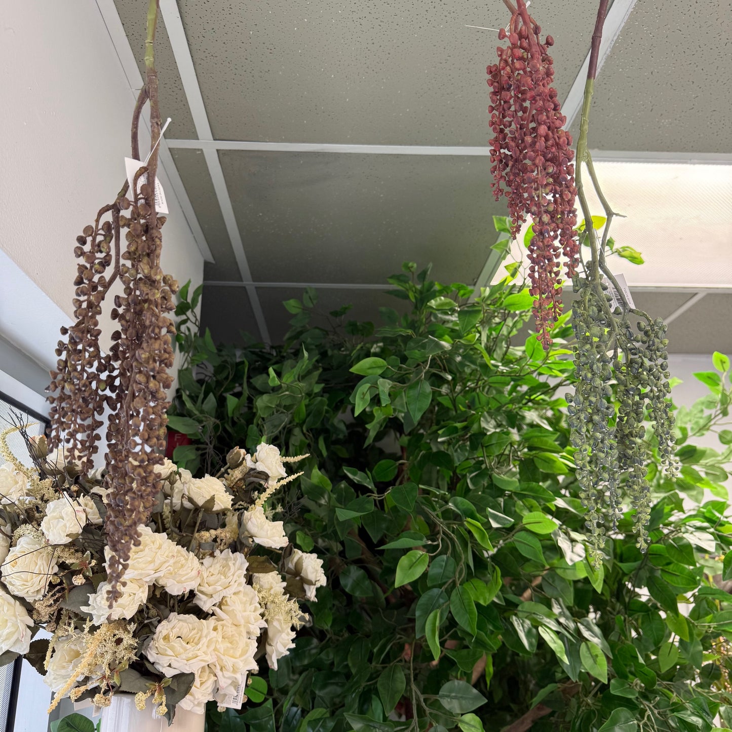 Hanging plants with dried flowers and greenery indoors.