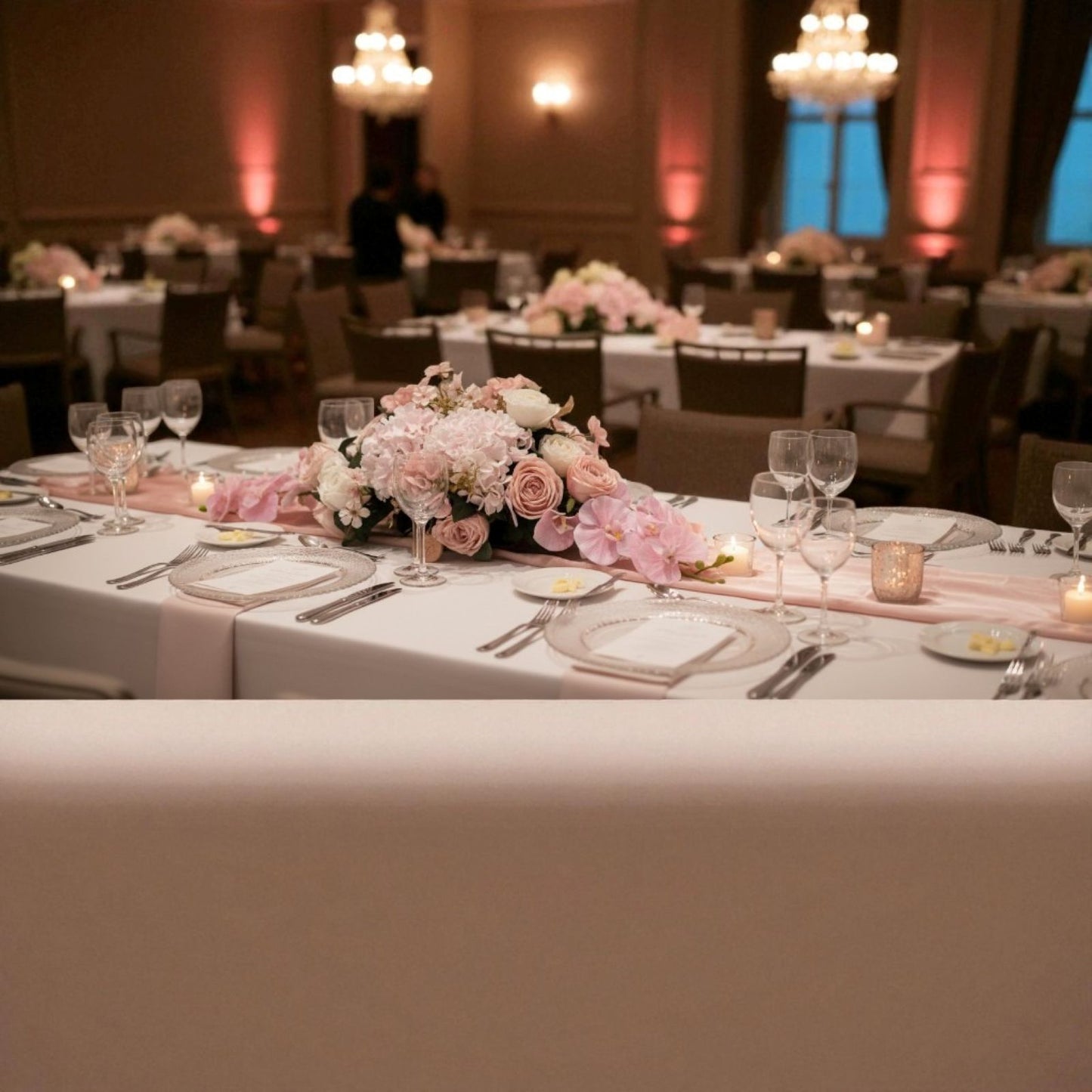 Decorated table with floral arrangements in a banquet hall.