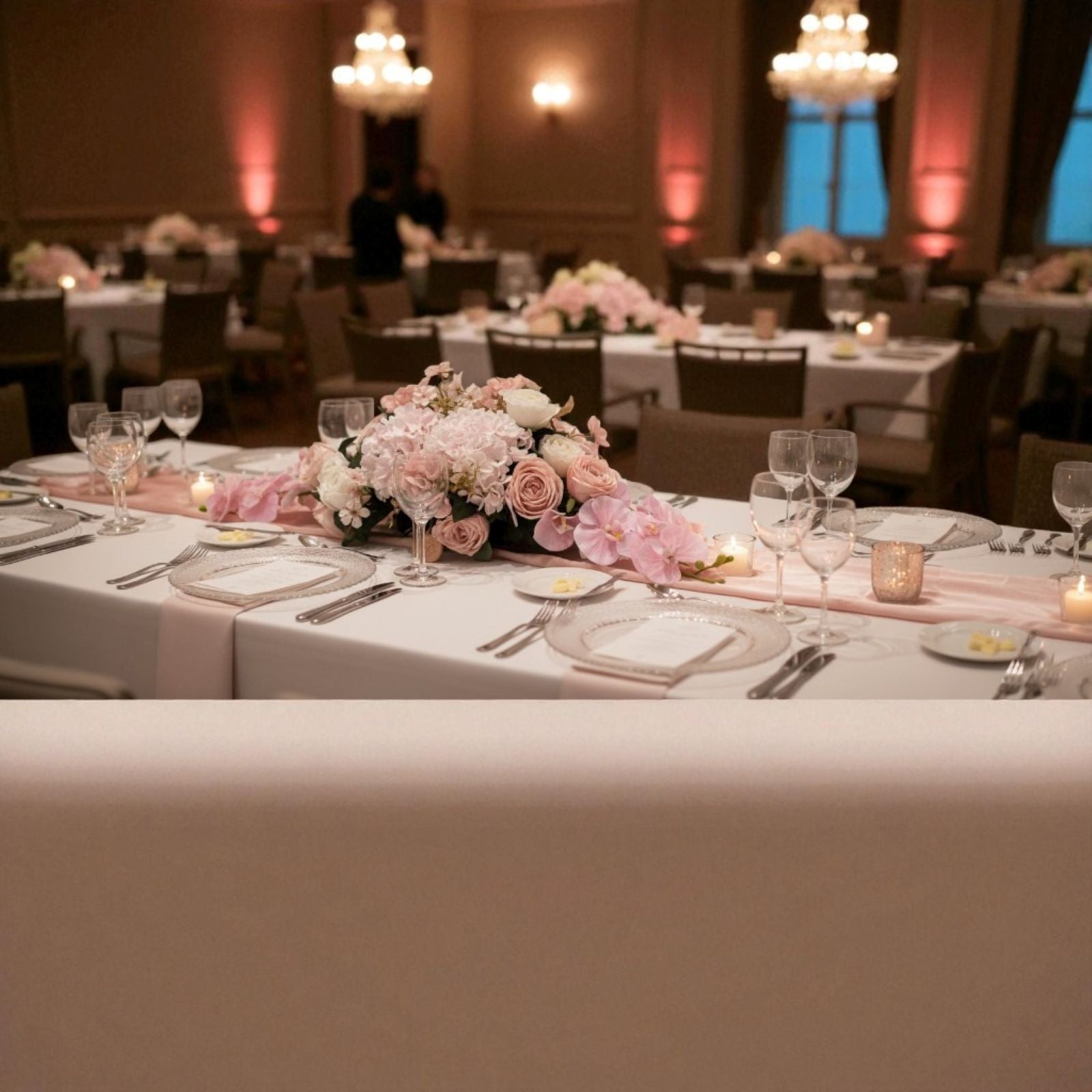 Decorated table with floral arrangements in a banquet hall.