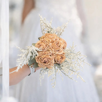 Bouquet of peach-colored roses held by a person against a blurred white background