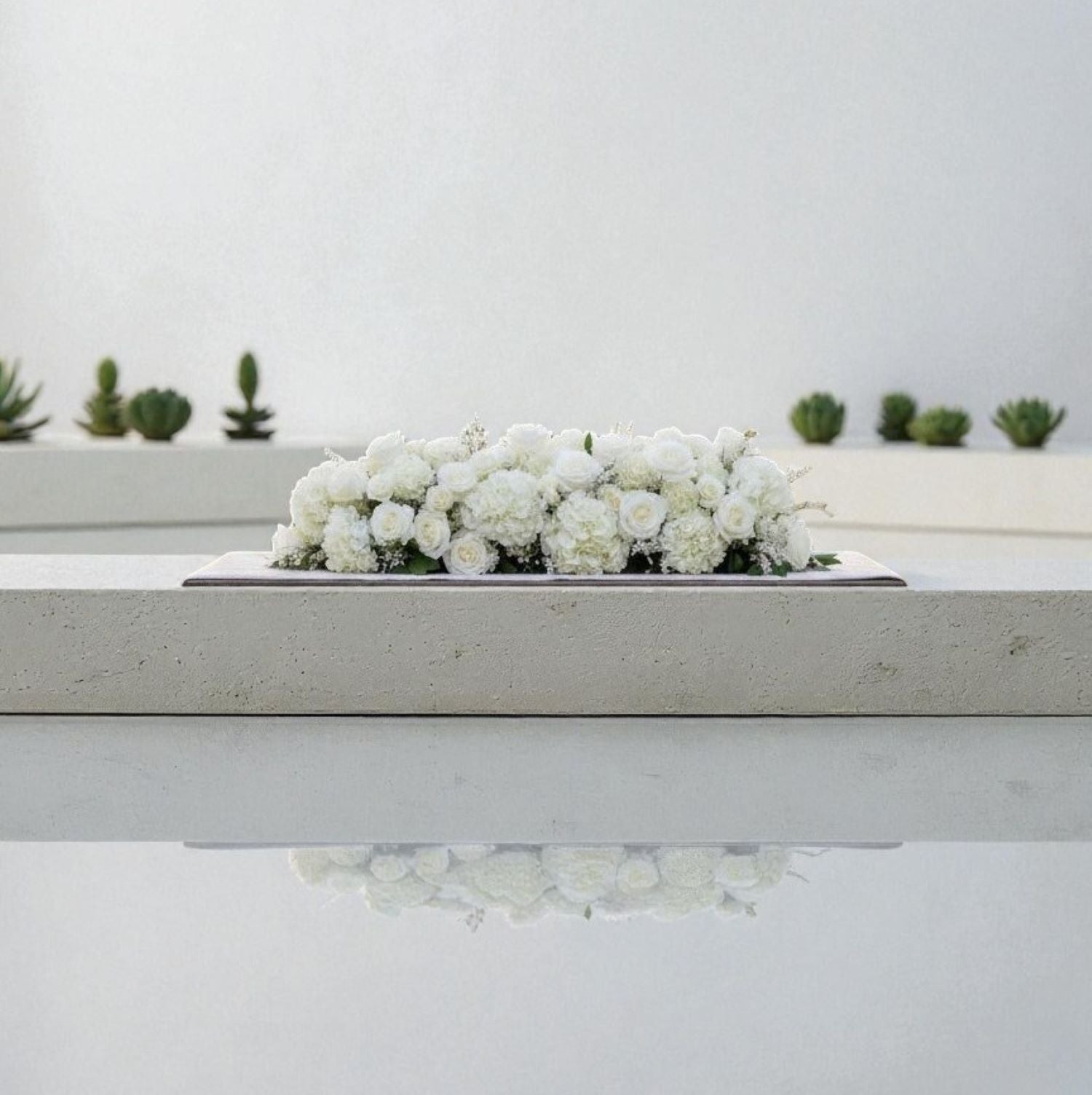 White floral arrangement on a white surface with a minimal background