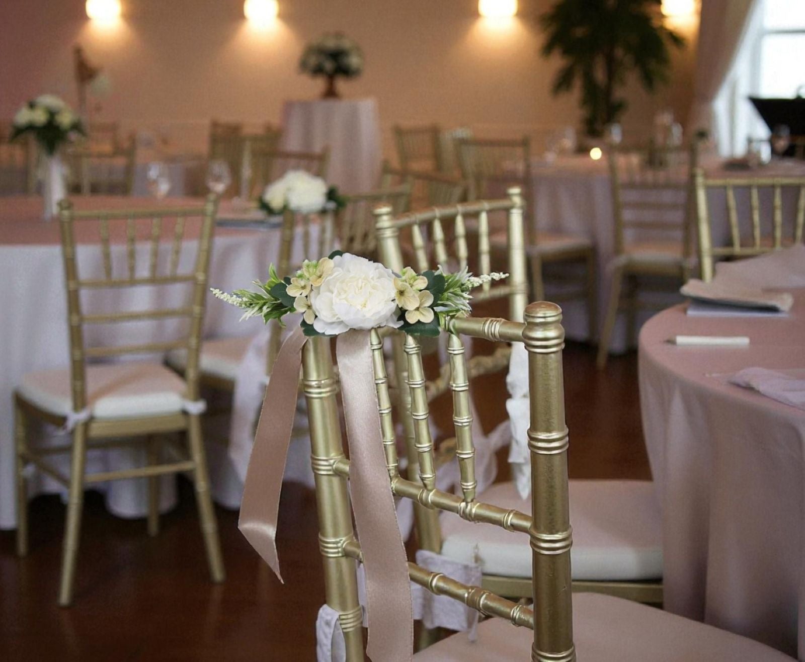 Decorated chairs with floral arrangements in a banquet hall.